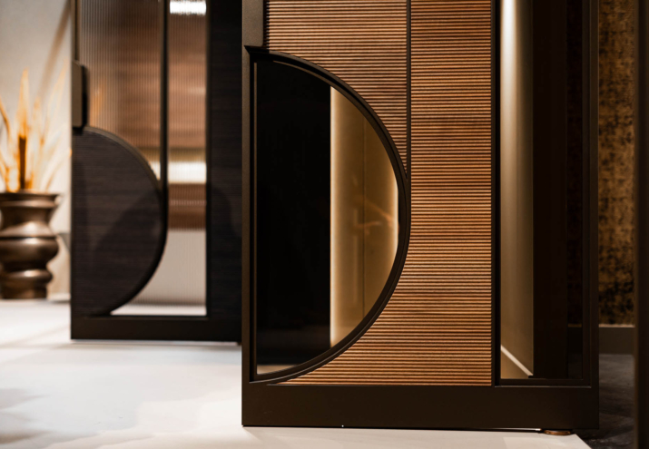Detail van bronskleurige stalen deur met fijne ribbelstructuur en elegante ronde belijning.