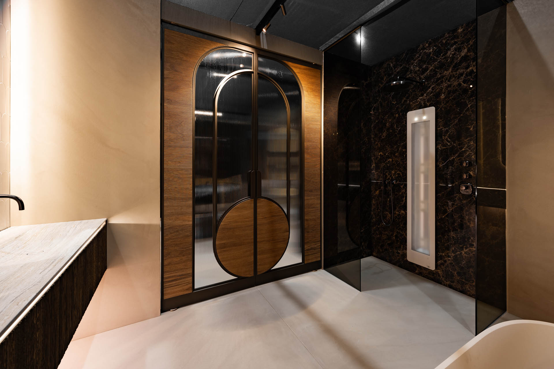 Luxe stalen badkamerdeur met ribbelglas, boogvormen en houten panelen naast marmeren douche.