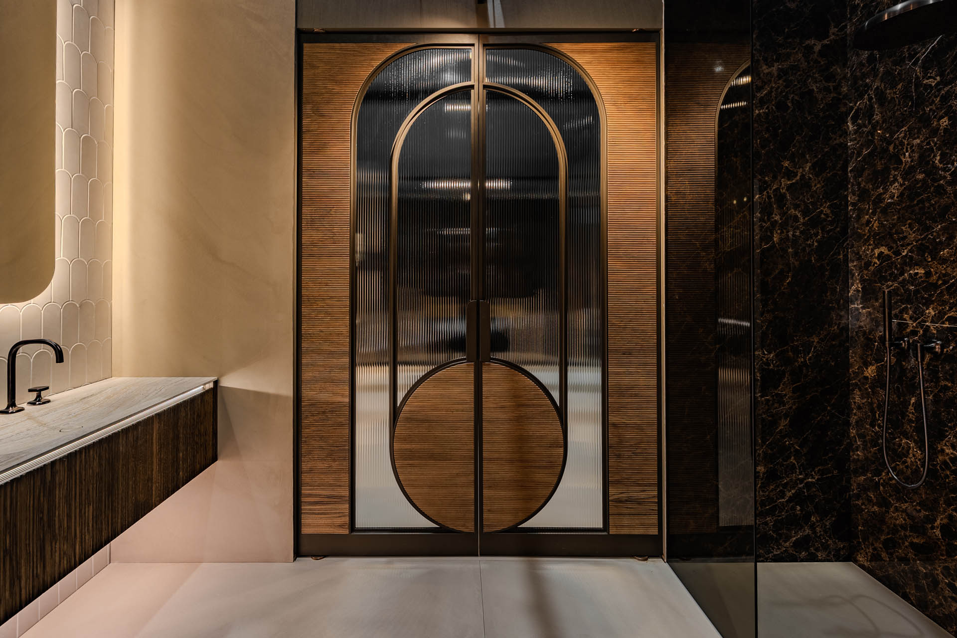 Moderne bronskleurige stalen taatsdeur met ribbelglas, houtaccenten en ronde designvormen.