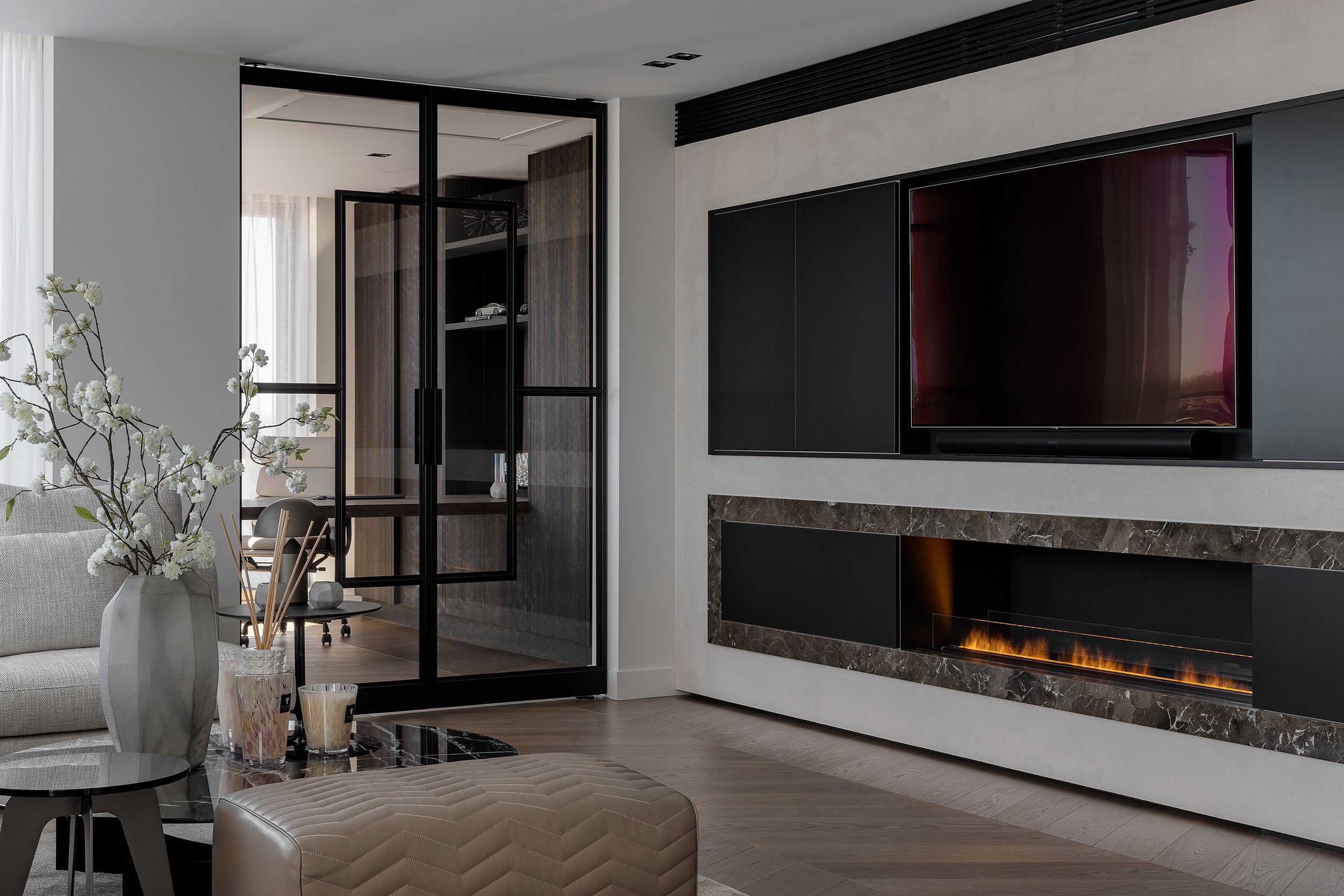 Zwarte stalen dubbele taatsdeuren met glas, geplaatst in een modern interieur met elektrische haard.