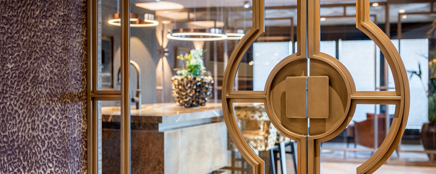 Messing stalen taatsdeuren met glas en opvallend rond handgreepdesign in luxe keukeninterieur.