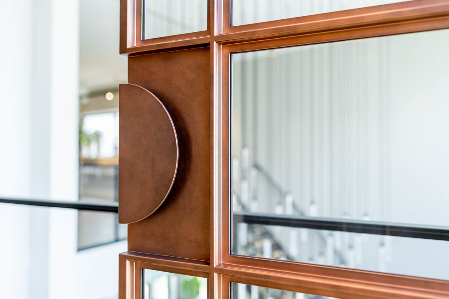 Exclusieve koperkleurige stalen deur met glas en op maat gemaakte ronde handgreep.