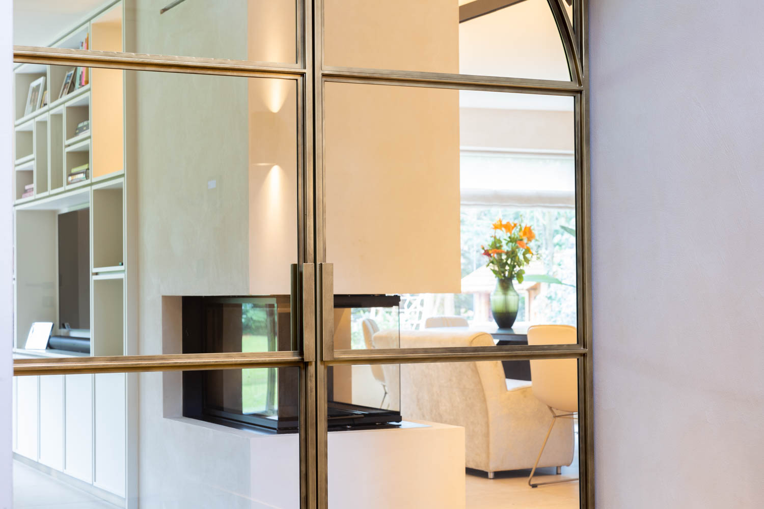 Luxe messing stalen taatsdeuren met glas in een modern interieur.
