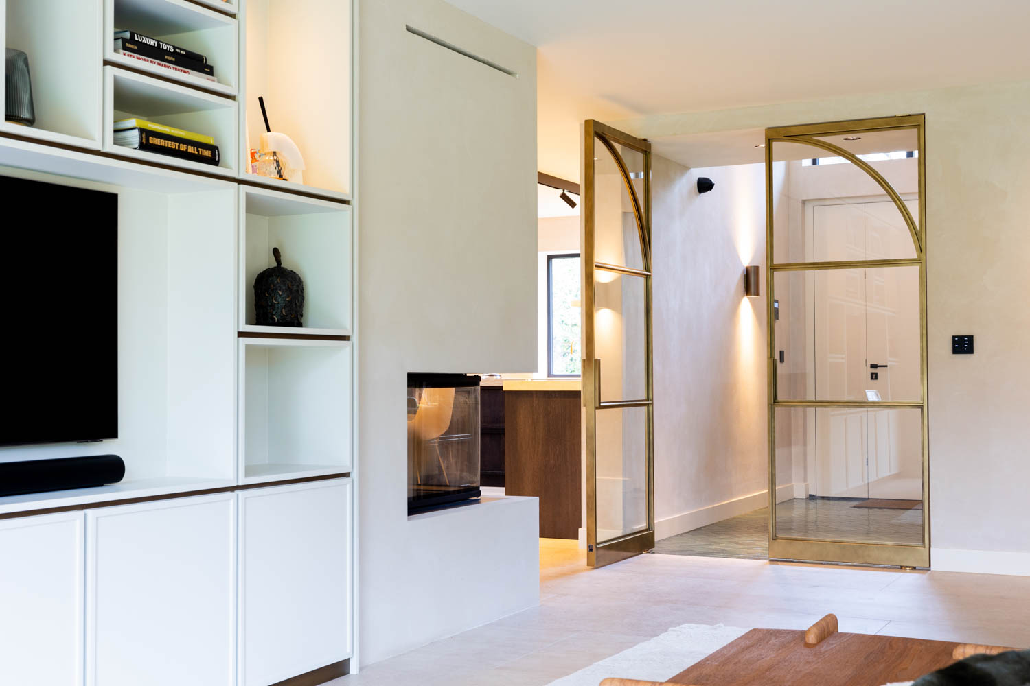 Open messing stalen taatsdeuren met glas in een modern interieur.