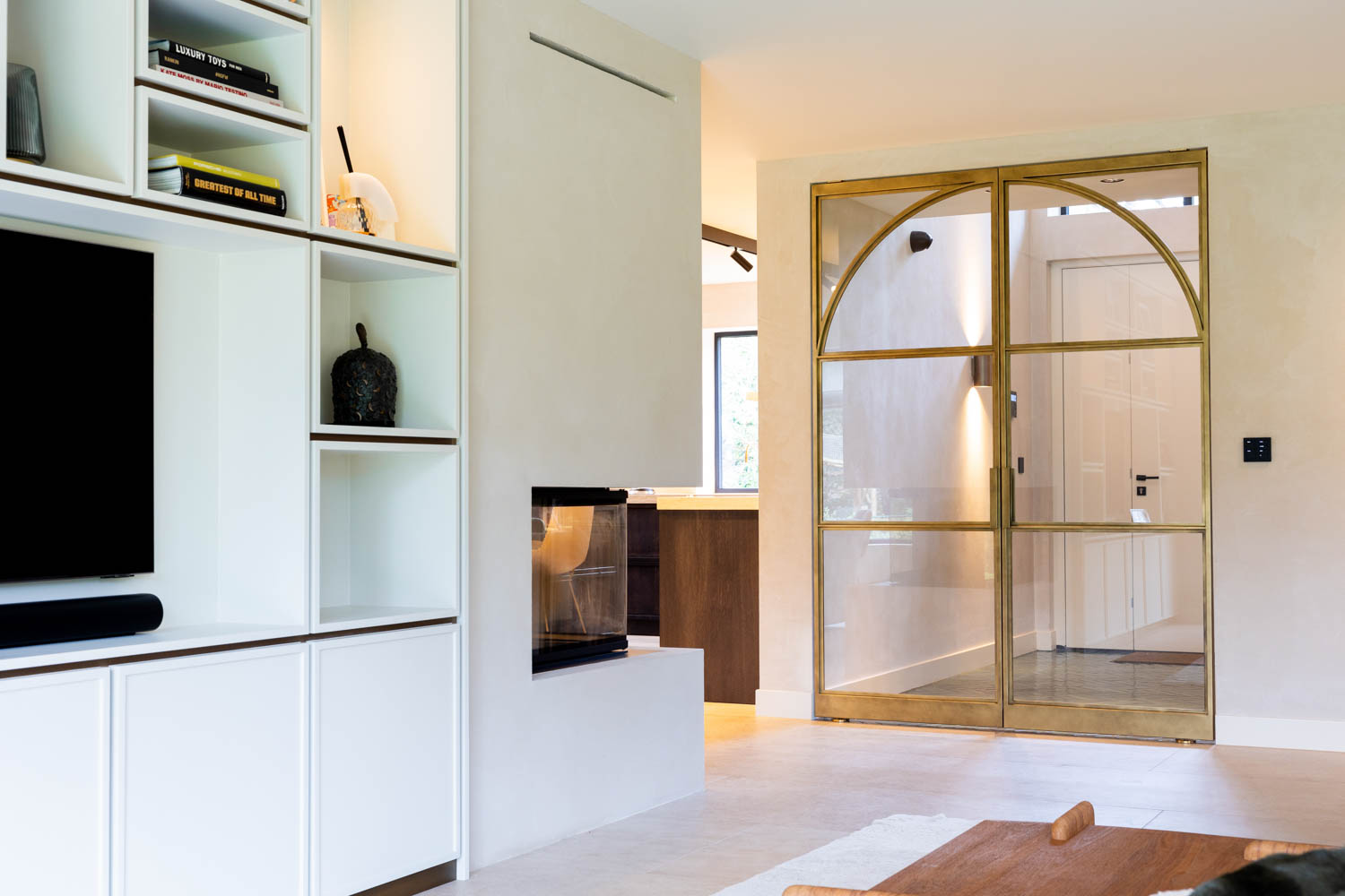 Gesloten messing stalen deuren met gebogen glasdetails in een stijlvolle woning.