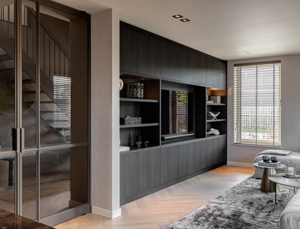 Anodic Brown stalen taatsdeur met glas in modern interieur met visgraatvloer en maatwerk kastenwand.