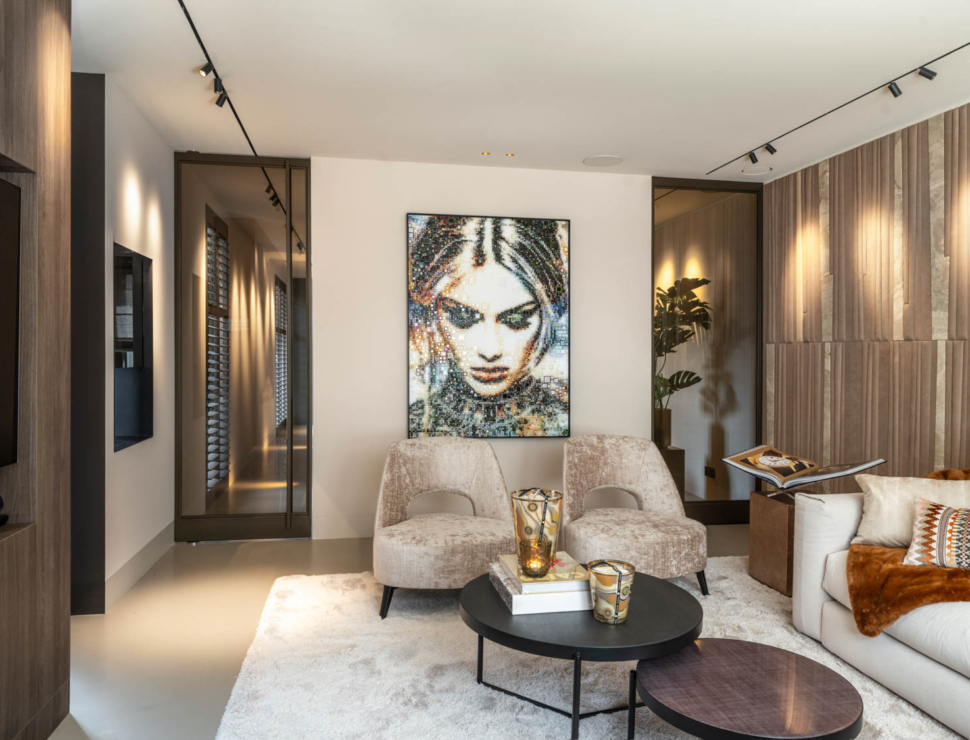 Modern interieur met Anodic bronzen stalen deuren en glas, warme beige tinten en een kunstwerk als eyecatcher.