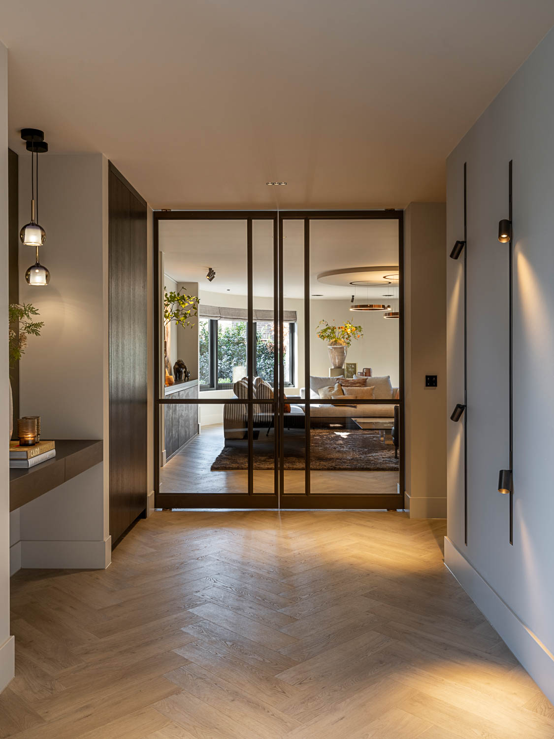 Dubbele bronzen stalen binnendeur met glas als chique roomdivider in luxe interieur.