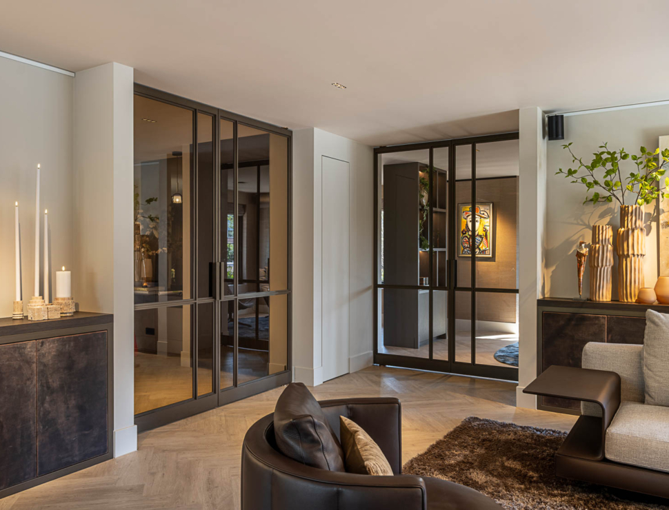 Stalen deuren met glas en bronzen afwerking creëren stijlvolle doorgang in designinterieur.