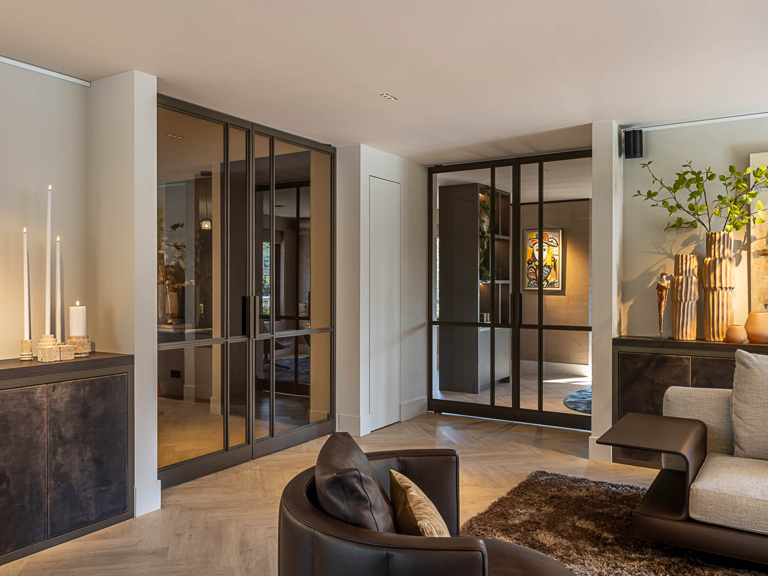 Stalen deuren met glas en bronzen afwerking creëren stijlvolle doorgang in designinterieur.