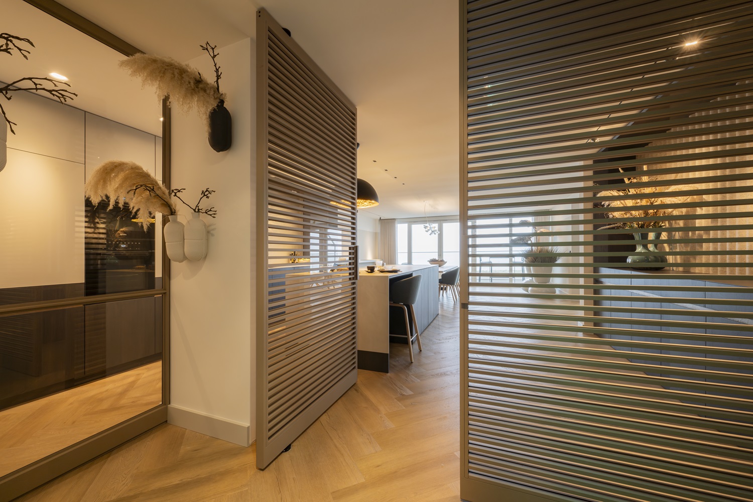 Moderne stalen roomdividers met horizontale lamellen in een luxe interieur met open keuken.