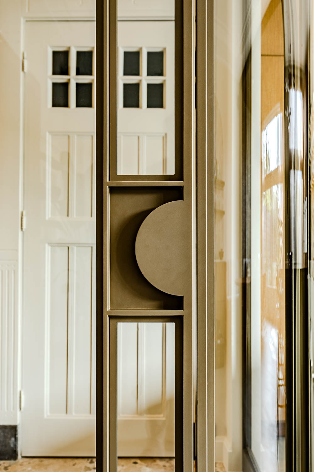 Bronzen stalen deur met glas en geïntegreerde ronde handgreep als luxe designaccent.