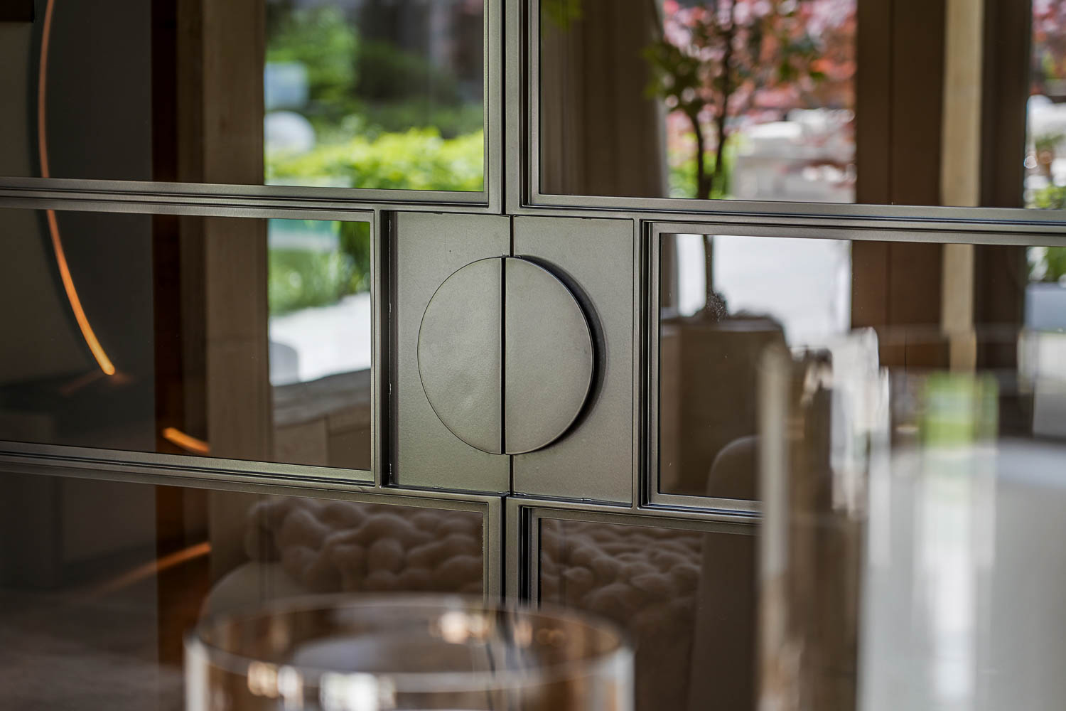 Detail van zwarte stalen taatsdeur met glas en elegante ronde handgreep.