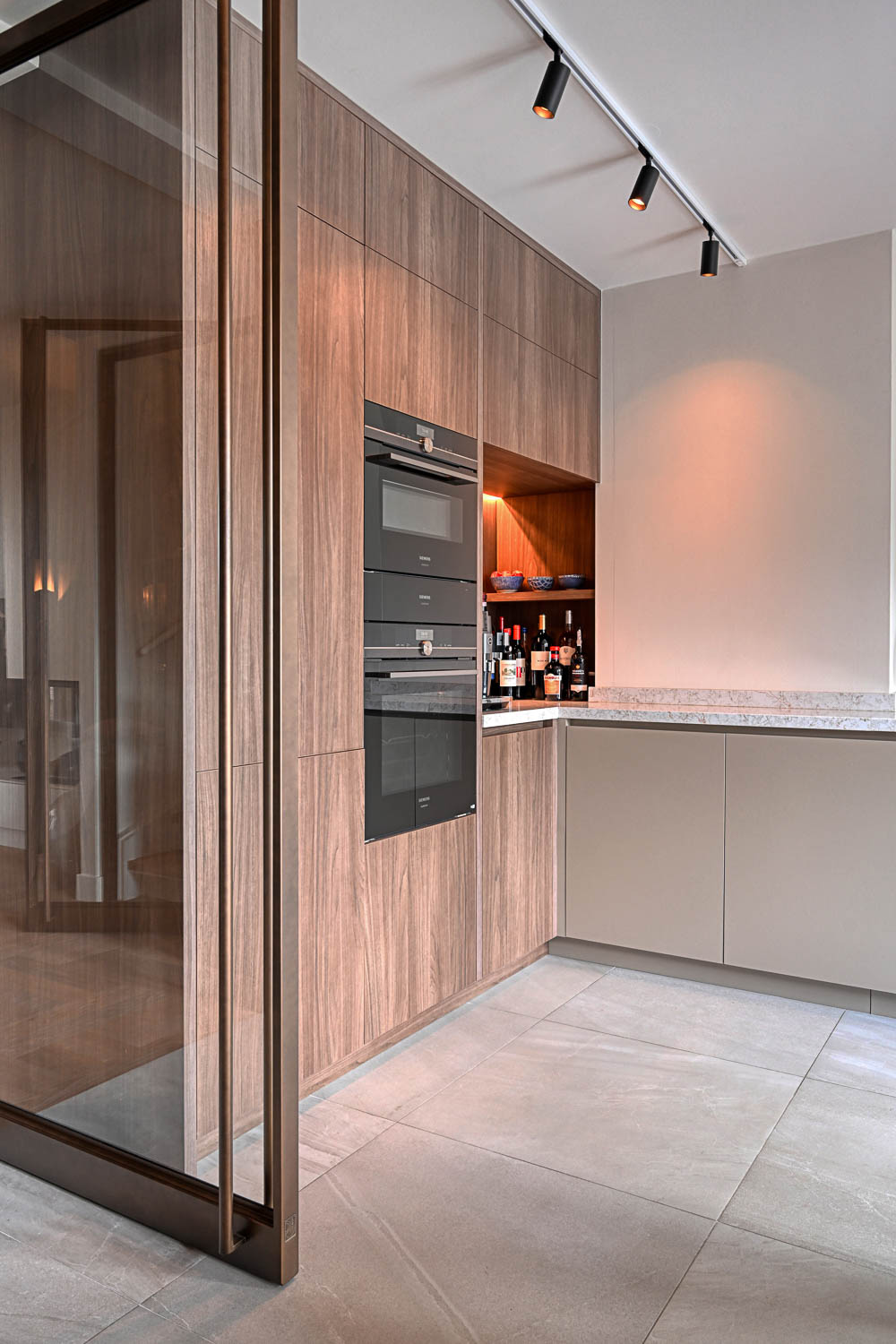 Stalen taatsdeur in bronzen afwerking met glas, vormt stijlvolle verbinding tussen eetkamer en woonkamer.