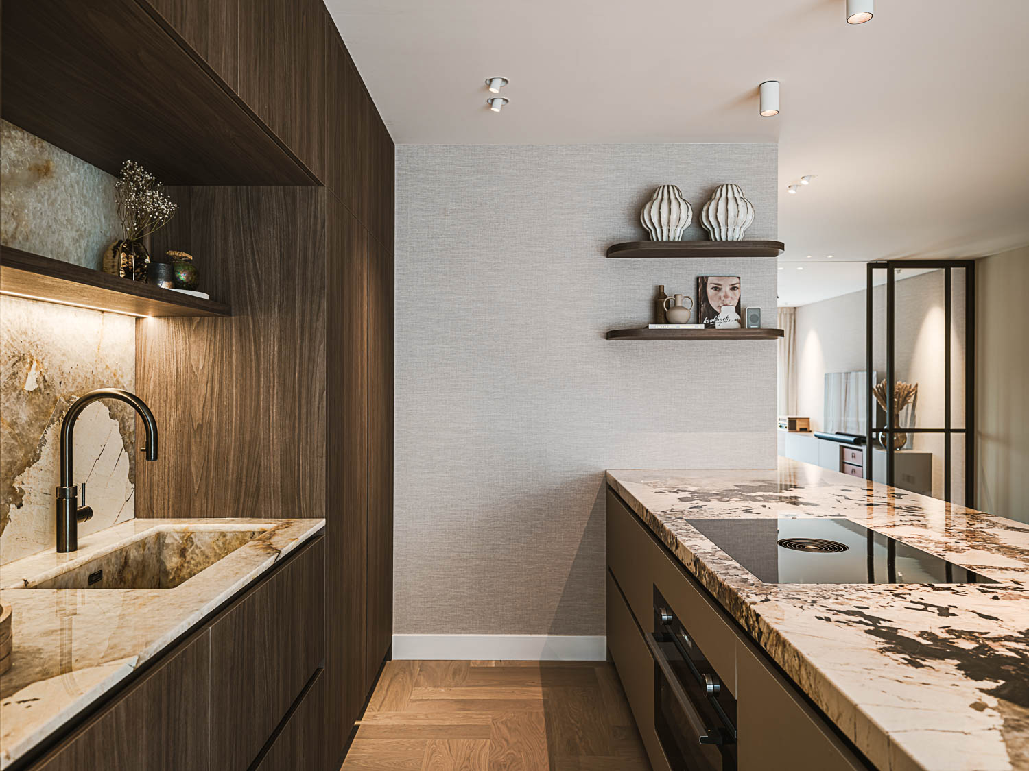 Design keuken met donkerhouten kasten, marmeren werkblad en stalen deur.