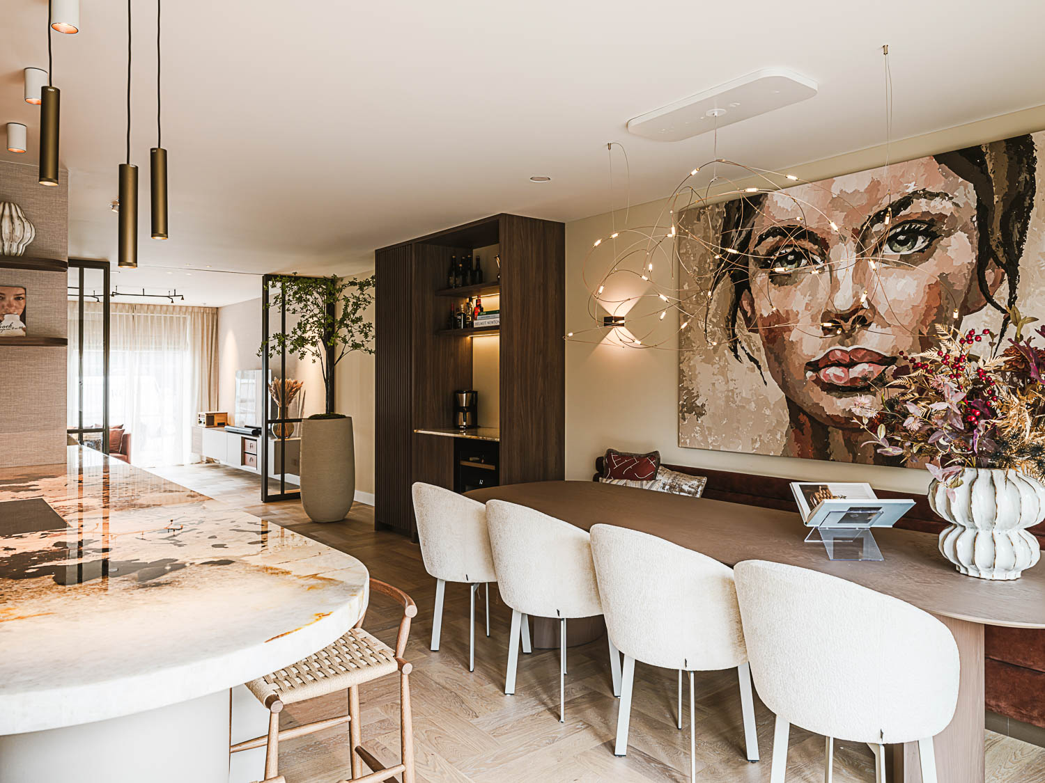 Luxe eetkamer met grote houten tafel, designstoelen en kunstwerk aan de muur in een modern interieur.