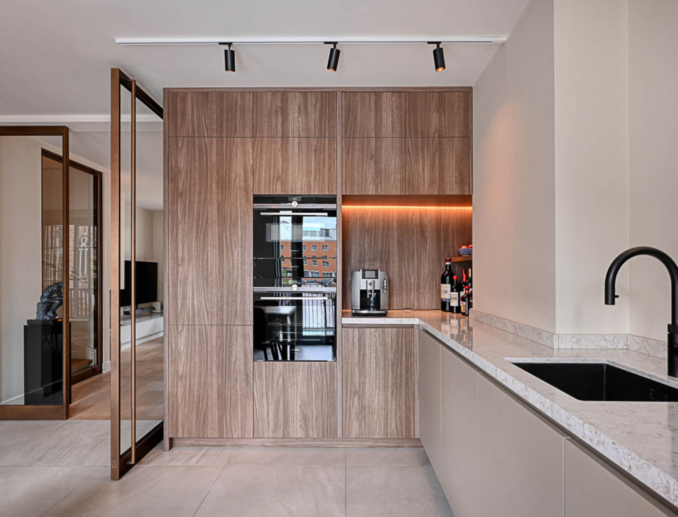 Moderne keuken met houten kastenwand en open bronzen stalen taatsdeur.