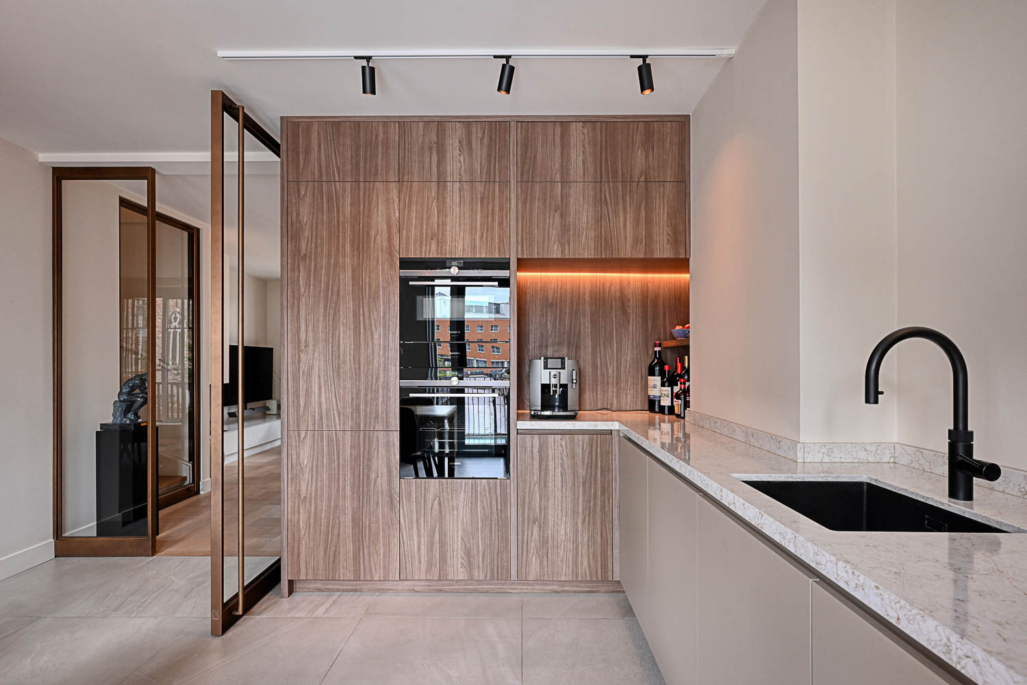 Moderne keuken met houten kastenwand en open bronzen stalen taatsdeur.