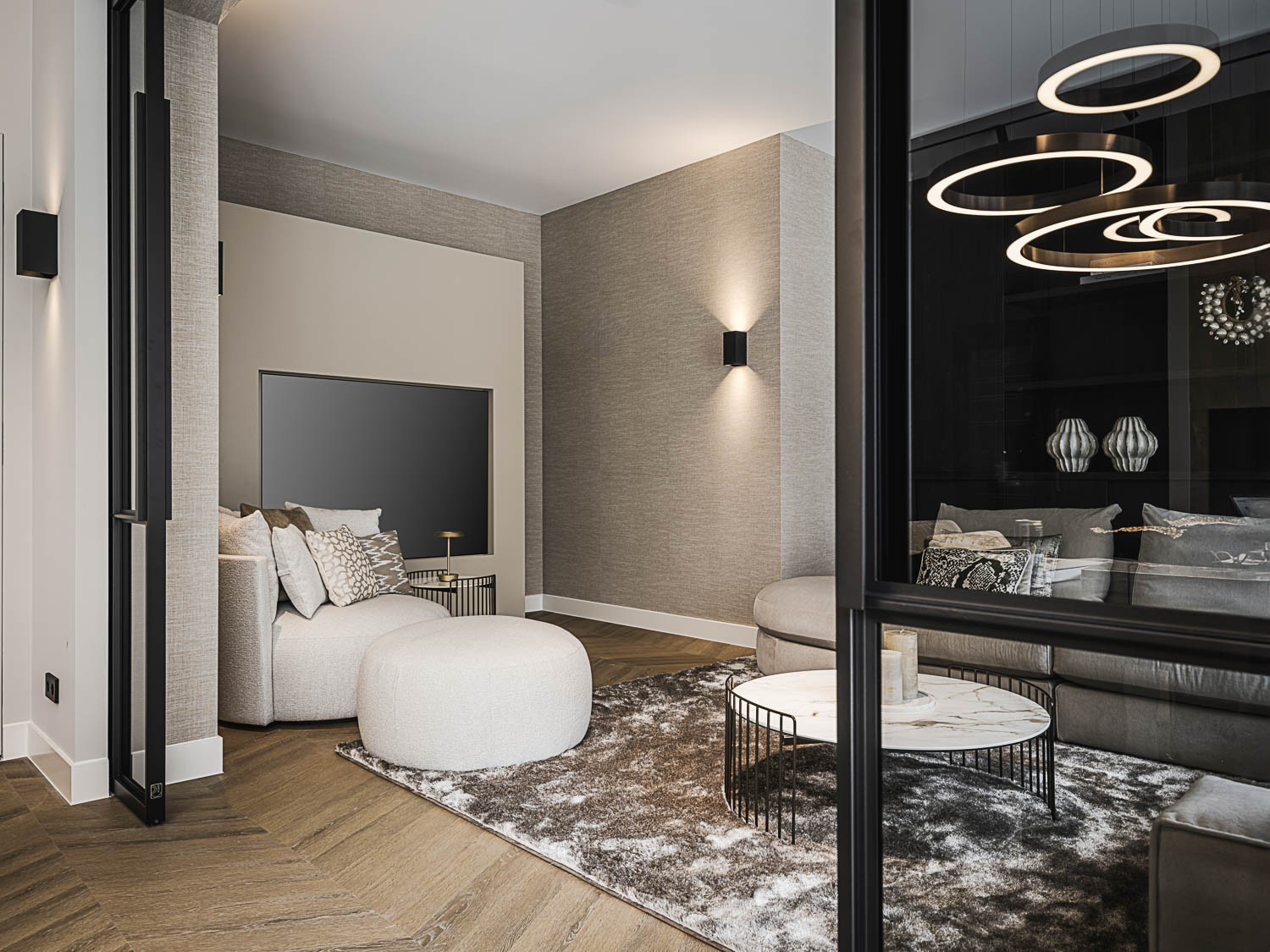 Moderne lounge met zwarte stalen deuren, marmeren salontafel en hoogpolig vloerkleed.